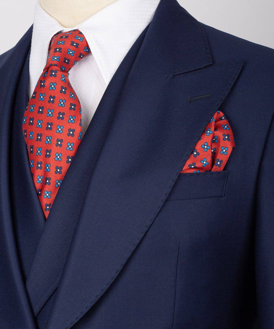 KOSS ATELIER men's navy three-piece suit on mannequin with white shirt red patterned tie and pocket square
