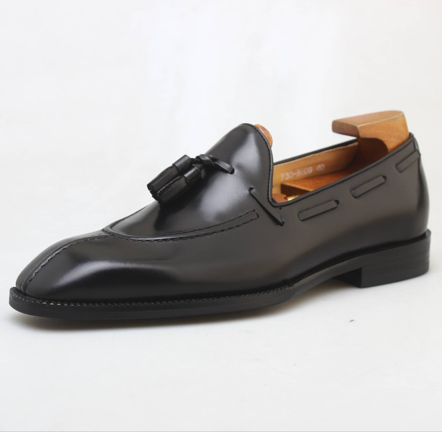 KOSS ATELIER black leather tassel loafers with a sleek design and elegant finish