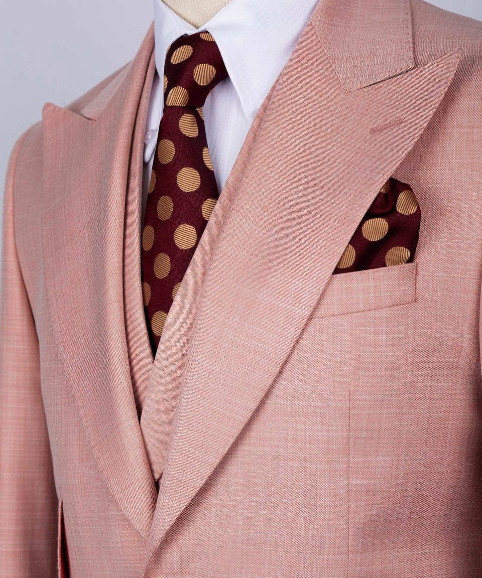 KOSS ATELIER men's rose pink three-piece suit close up with white shirt burgundy polka dot tie and pocket square