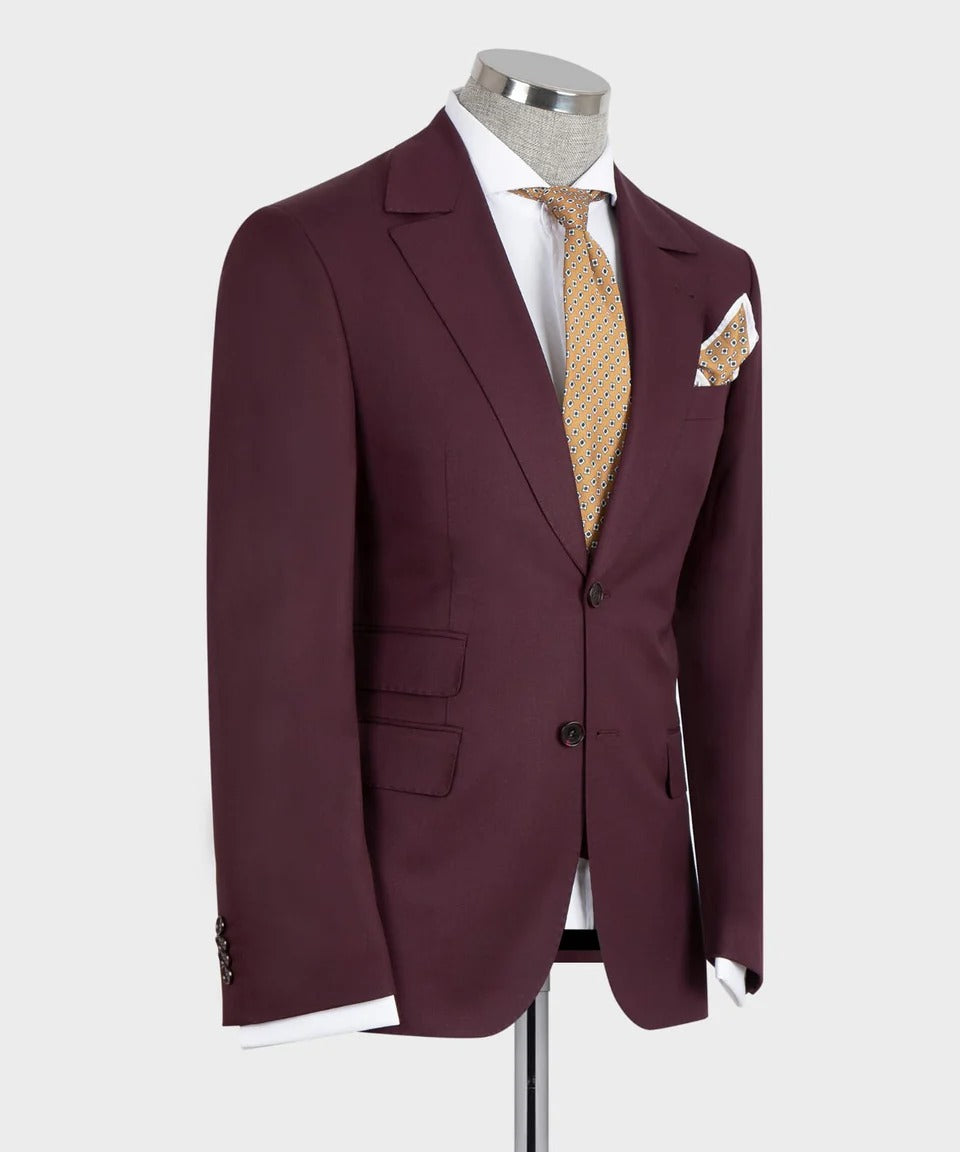 KOSS ATELIER burgundy 3-piece suit for men on mannequin with notch lapel two-button jacket gold patterned tie and pocket square