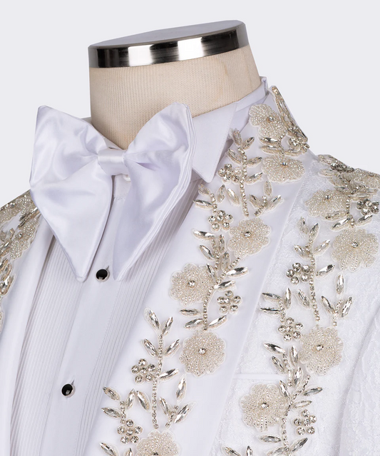 White dress shirt with intricate gold embroidery and a white bow tie on a mannequin.