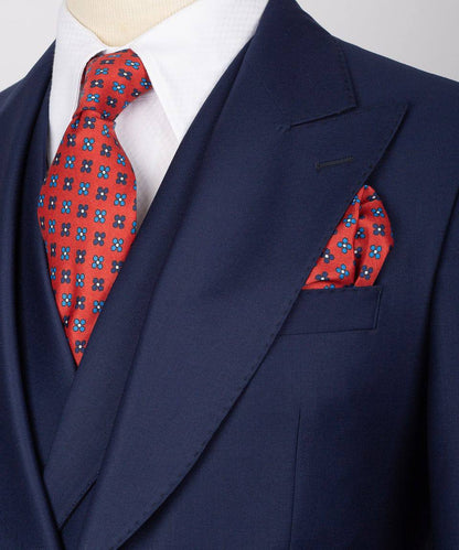 KOSS ATELIER men's navy three-piece suit on mannequin with white shirt red patterned tie and pocket square