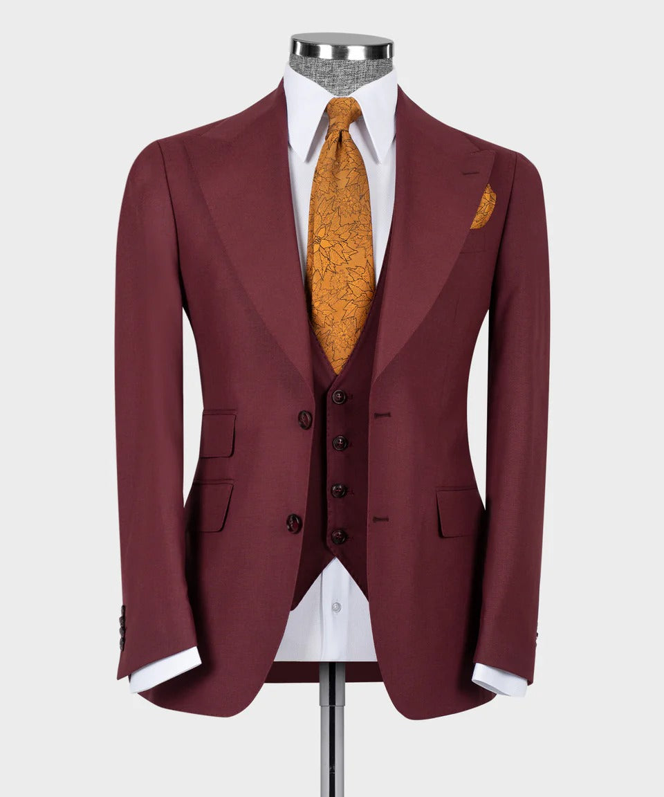 KOSS ATELIER maroon three piece suit for men on mannequin with white dress shirt and gold patterned tie and pocket square