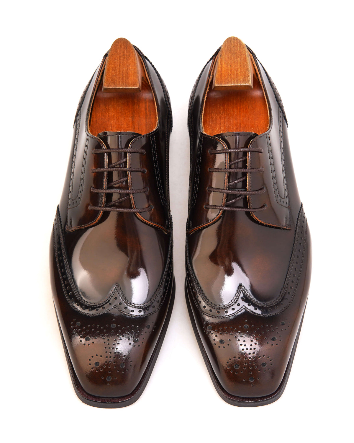 Elegant brown patent wingtip oxford shoes with detailed brogue design and polished finish