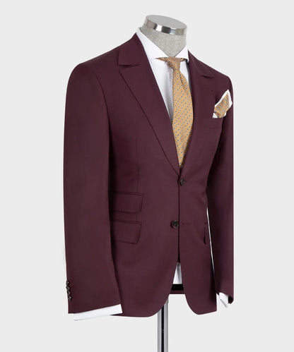 KOSS ATELIER burgundy 3-piece suit for men on mannequin with notch lapel two-button jacket gold patterned tie and pocket square
